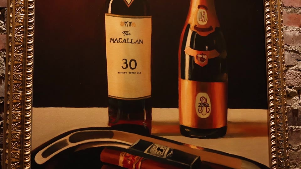 Framed bottle-and-cigar artwork in a Red Phone Booth lounge.