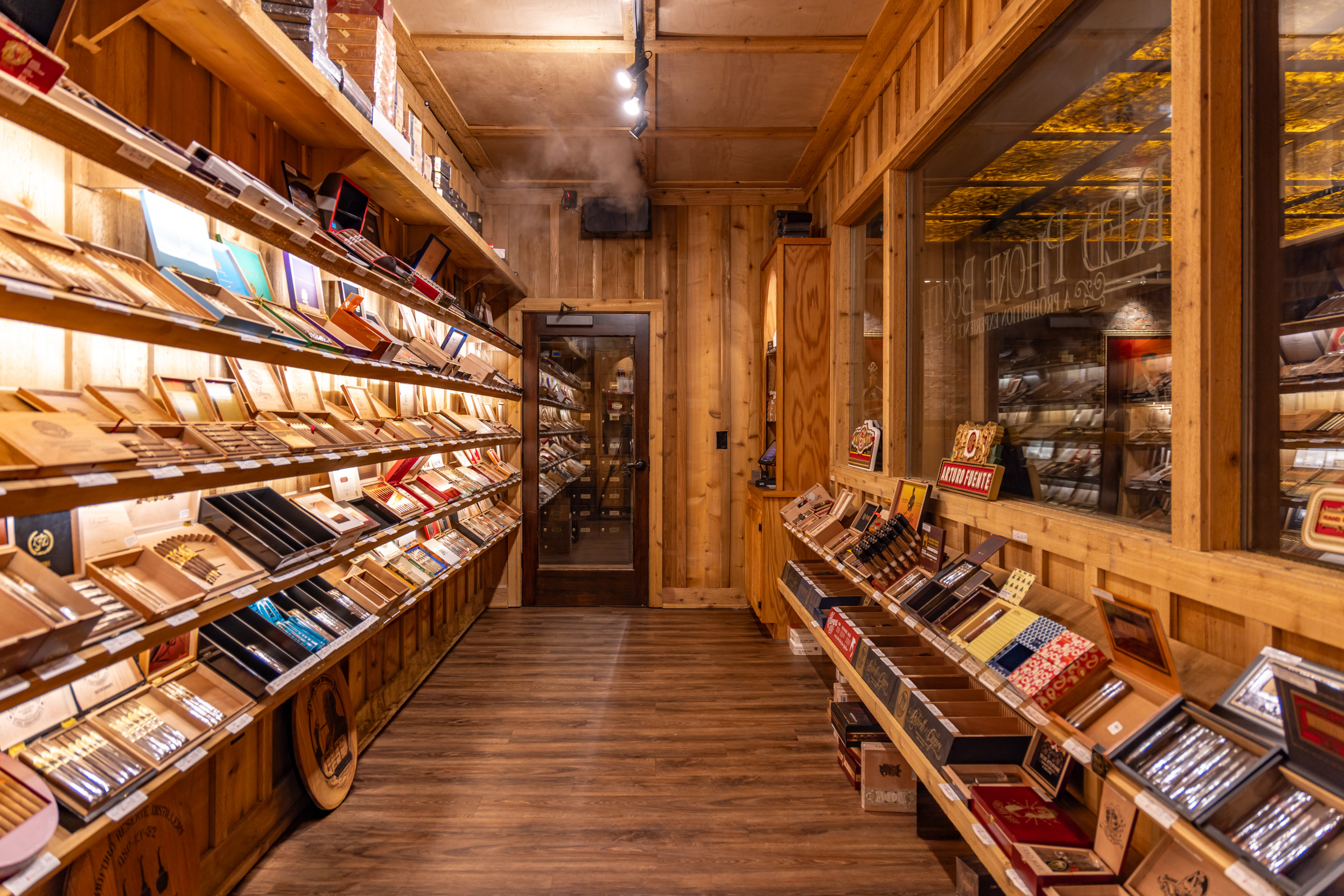 Cedar shelves of premium cigars inside a Red Phone Booth walk-in humidor.