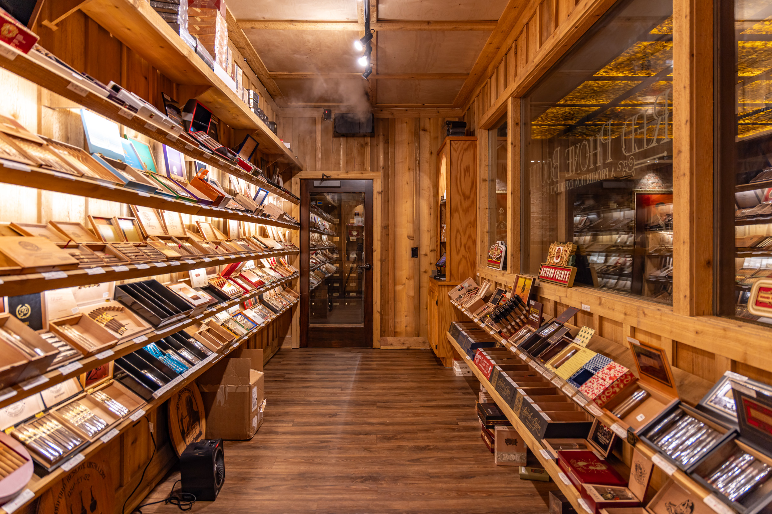 Cedar shelves of premium cigars inside a Red Phone Booth walk-in humidor.