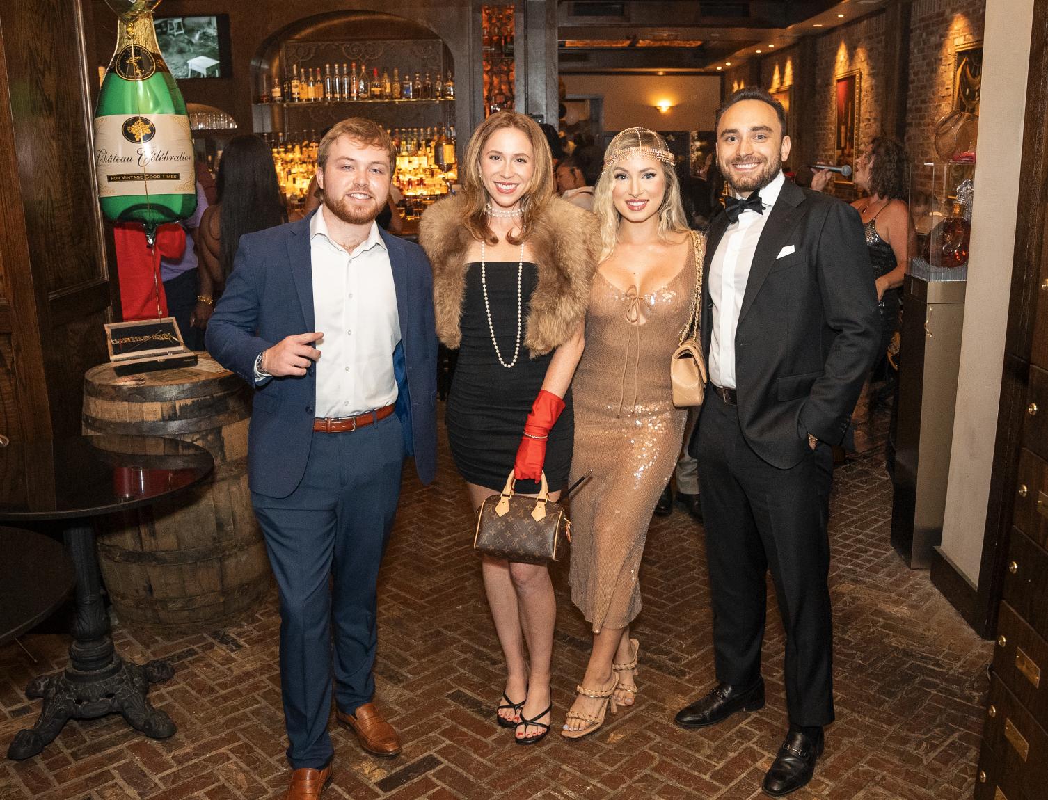 Four guests dressed for a celebration inside Red Phone Booth.